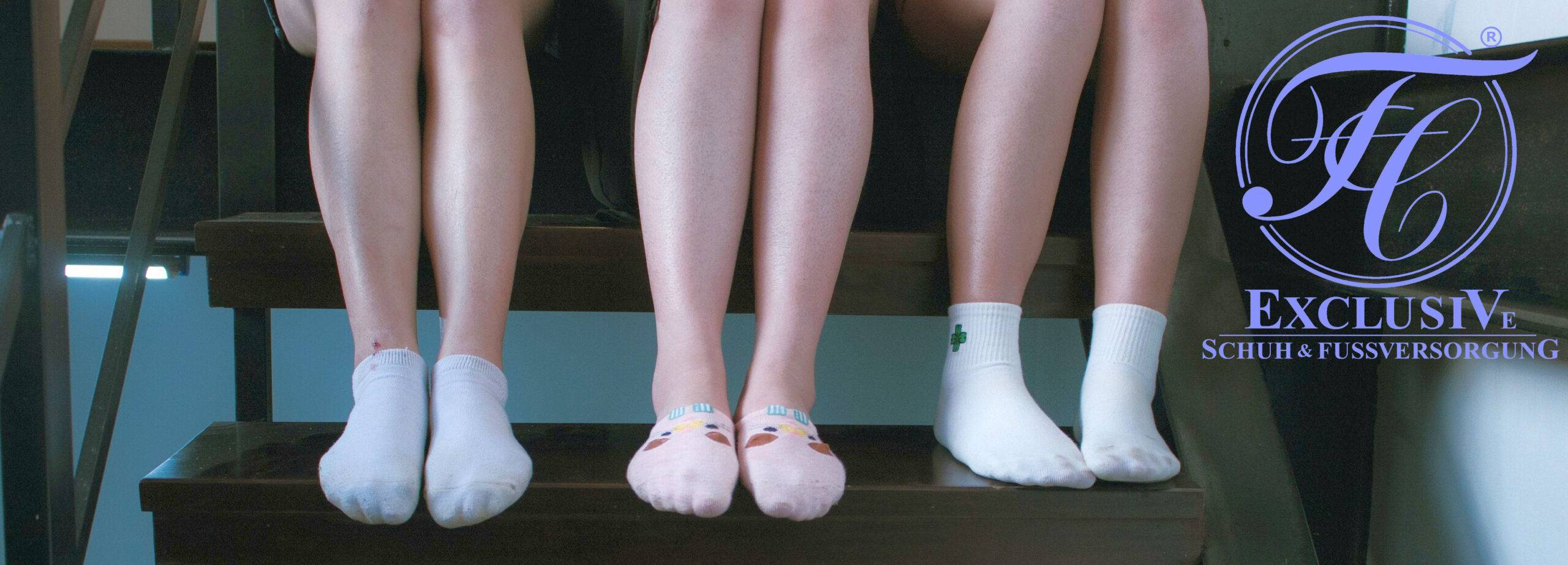 Kinder auf der Treppe, die ihre Füße in Socken präsentieren